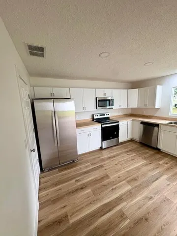 a large kitchen with a stove a refrigerator and a sink