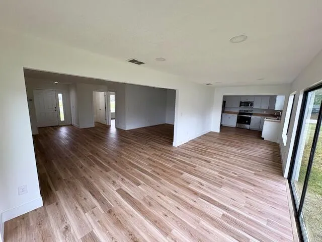 a view of empty room with wooden floor