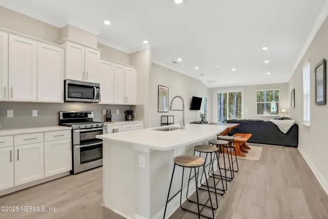 a kitchen with a table chairs a stove a microwave a dining table and chairs