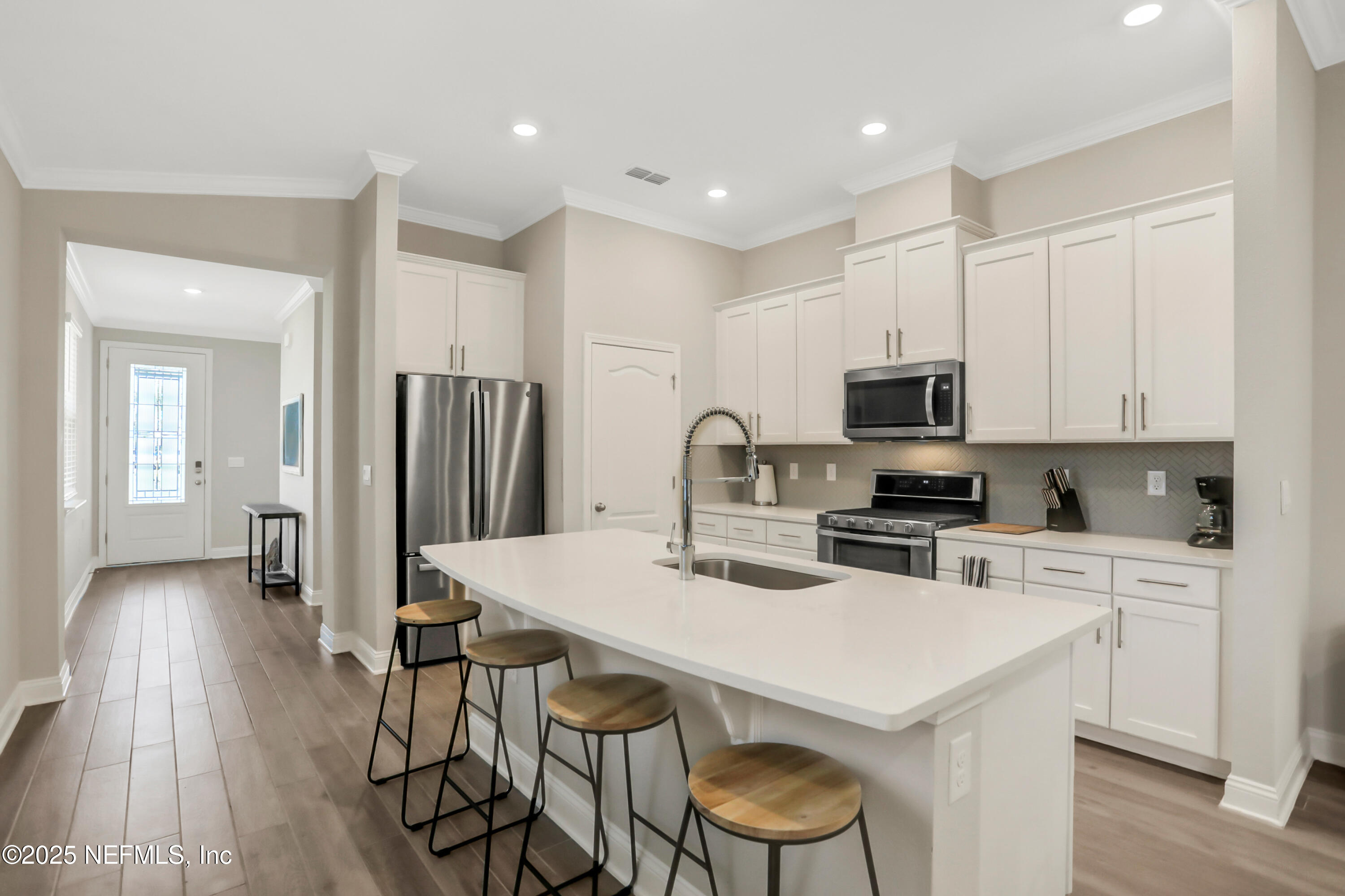 404 Thistleton Way Street St. Augustine, FL 32092 - Photo 5 of 36 a kitchen with stainless steel appliances a stove a sink a refrigerator white cabinets and wooden floor