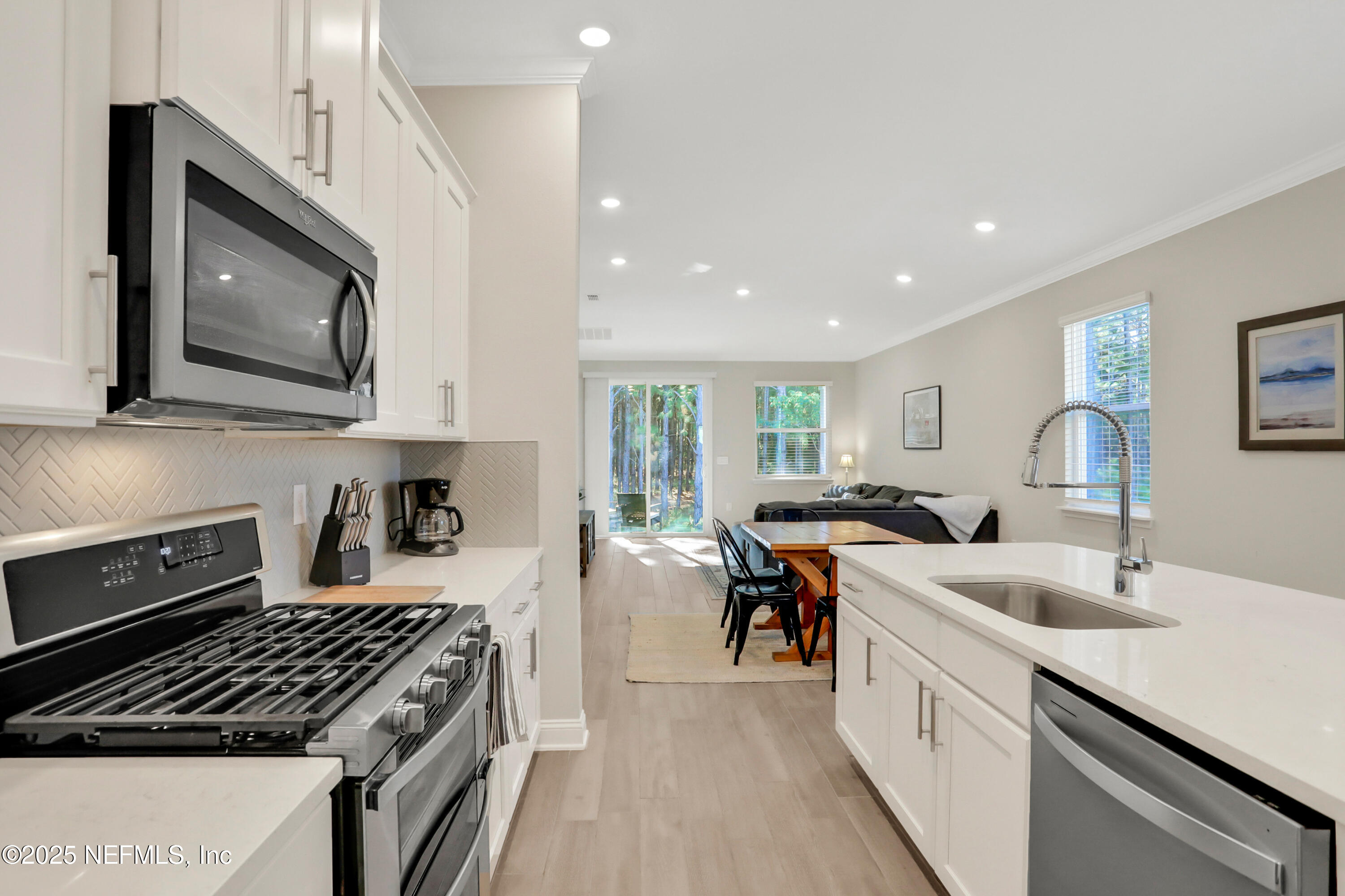 404 Thistleton Way Street St. Augustine, FL 32092 - Photo 7 of 36 a kitchen with stainless steel appliances a stove sink microwave and cabinets