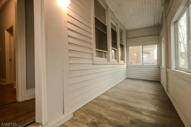 a view of a porch with wooden floor and a window