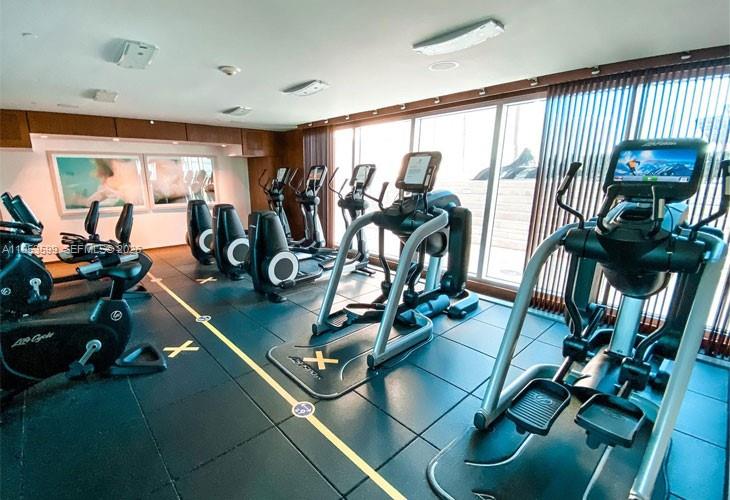 325 South Biscayne Boulevard, Unit 3314 Miami, FL 33131 - Photo 27 of 30 a room with gym equipment and large mirror