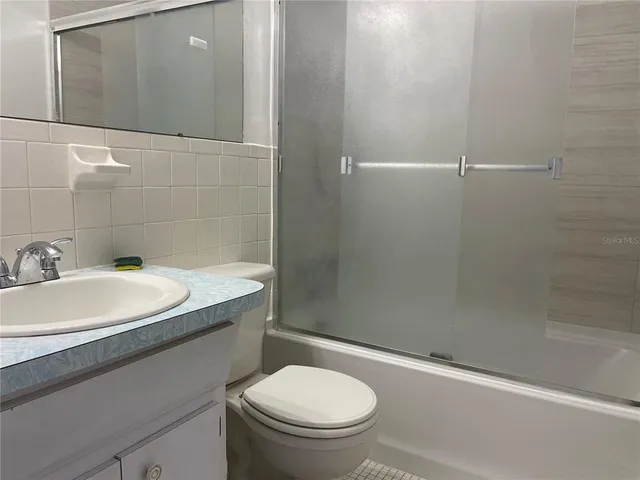 an empty room with a chandelier fan and windows