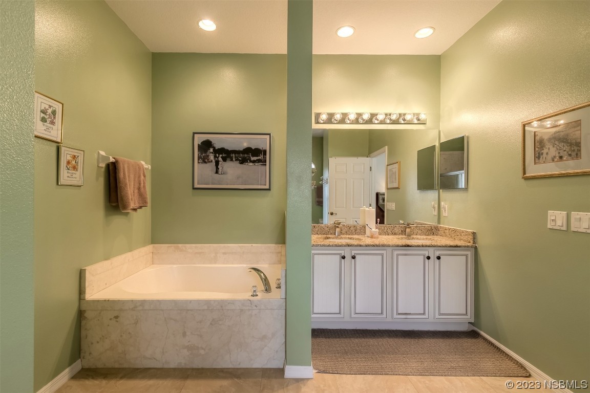 313 Mariners Gate Drive Edgewater, FL 32141 - Photo 22 of 55 a bathroom with a tub a sink and mirror