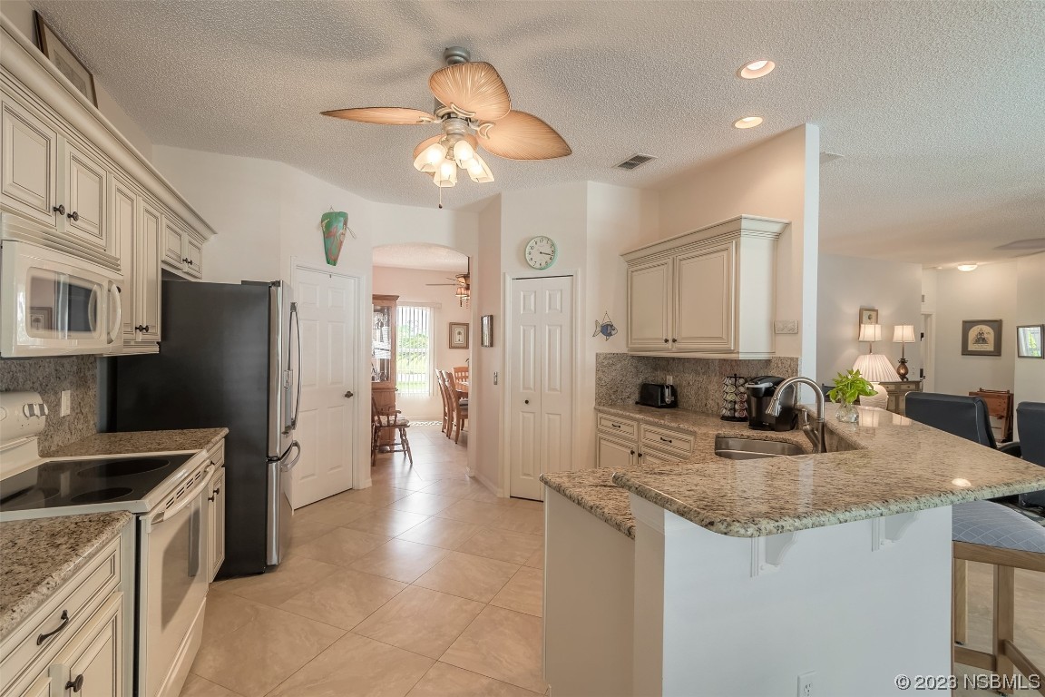 313 Mariners Gate Drive Edgewater, FL 32141 - Photo 34 of 55 a kitchen with stainless steel appliances granite countertop a sink refrigerator and cabinets