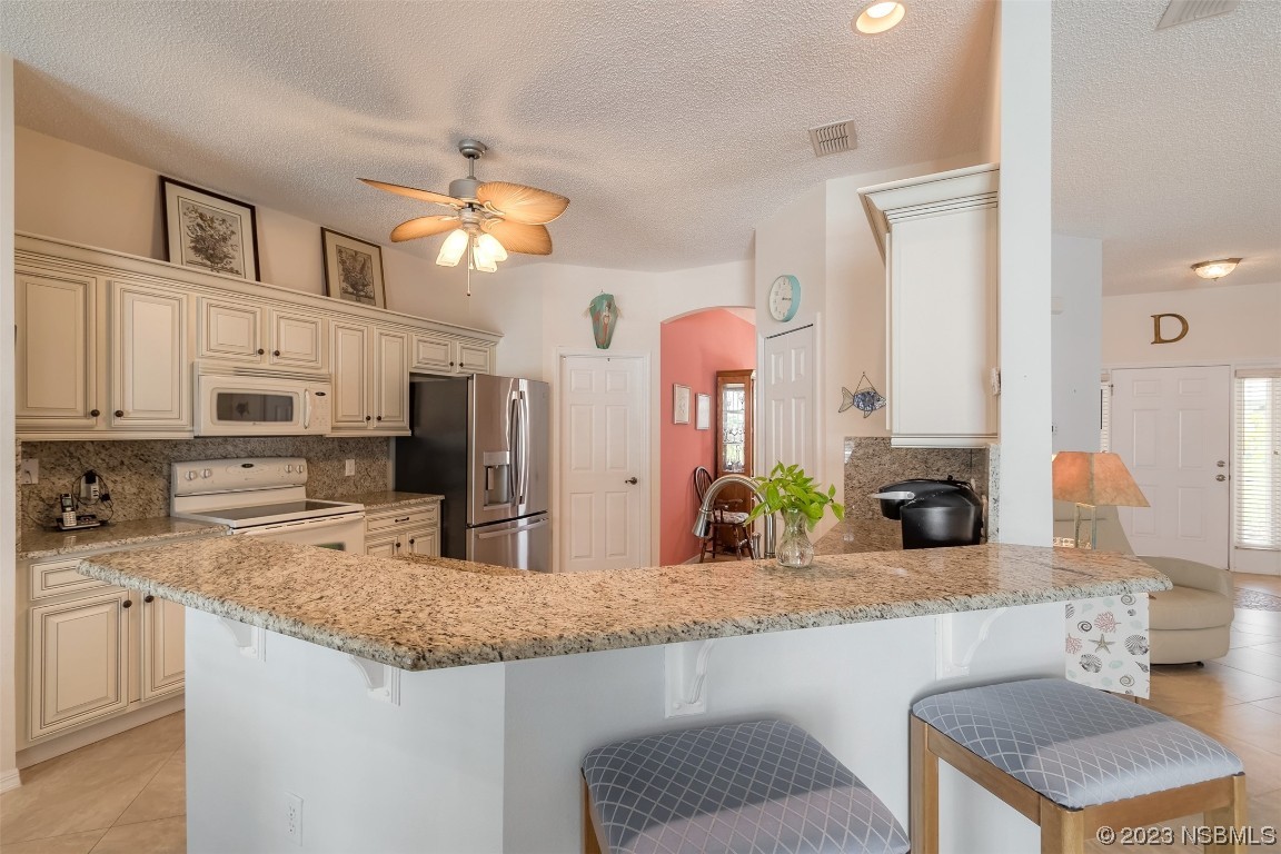 313 Mariners Gate Drive Edgewater, FL 32141 - Photo 35 of 55 a kitchen with stainless steel appliances granite countertop a sink and a refrigerator