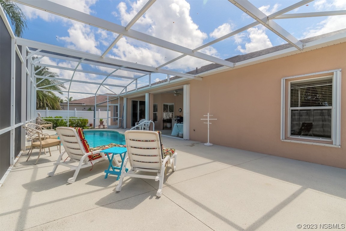 313 Mariners Gate Drive Edgewater, FL 32141 - Photo 43 of 55 a view of a patio with a dining table and chairs with a barbeque grill and a fireplace
