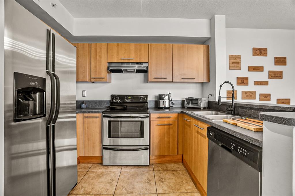 471 Northeast 25th Street, Unit 503 Miami, FL 33137 - Photo 16 of 29 a kitchen with stainless steel appliances a stove sink and refrigerator