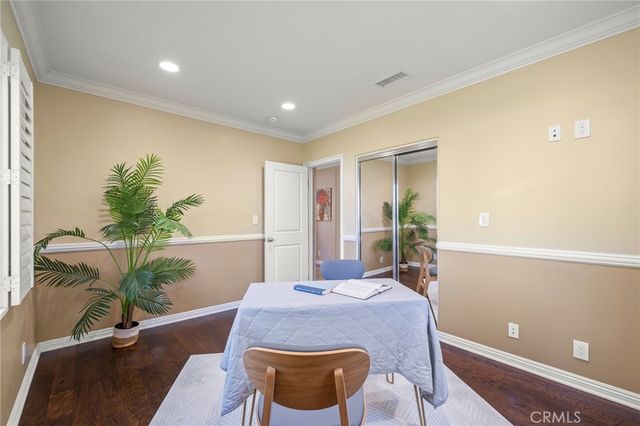 a bedroom with a bed lamp and a large window with wooden floor