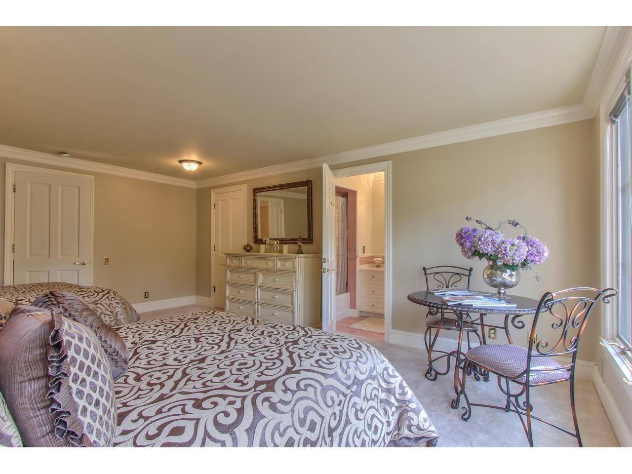 3140 Spruance Road Pebble Beach, CA 93953 - Photo 53 of 70 a bedroom with a bed and a chair with the wooden floor
