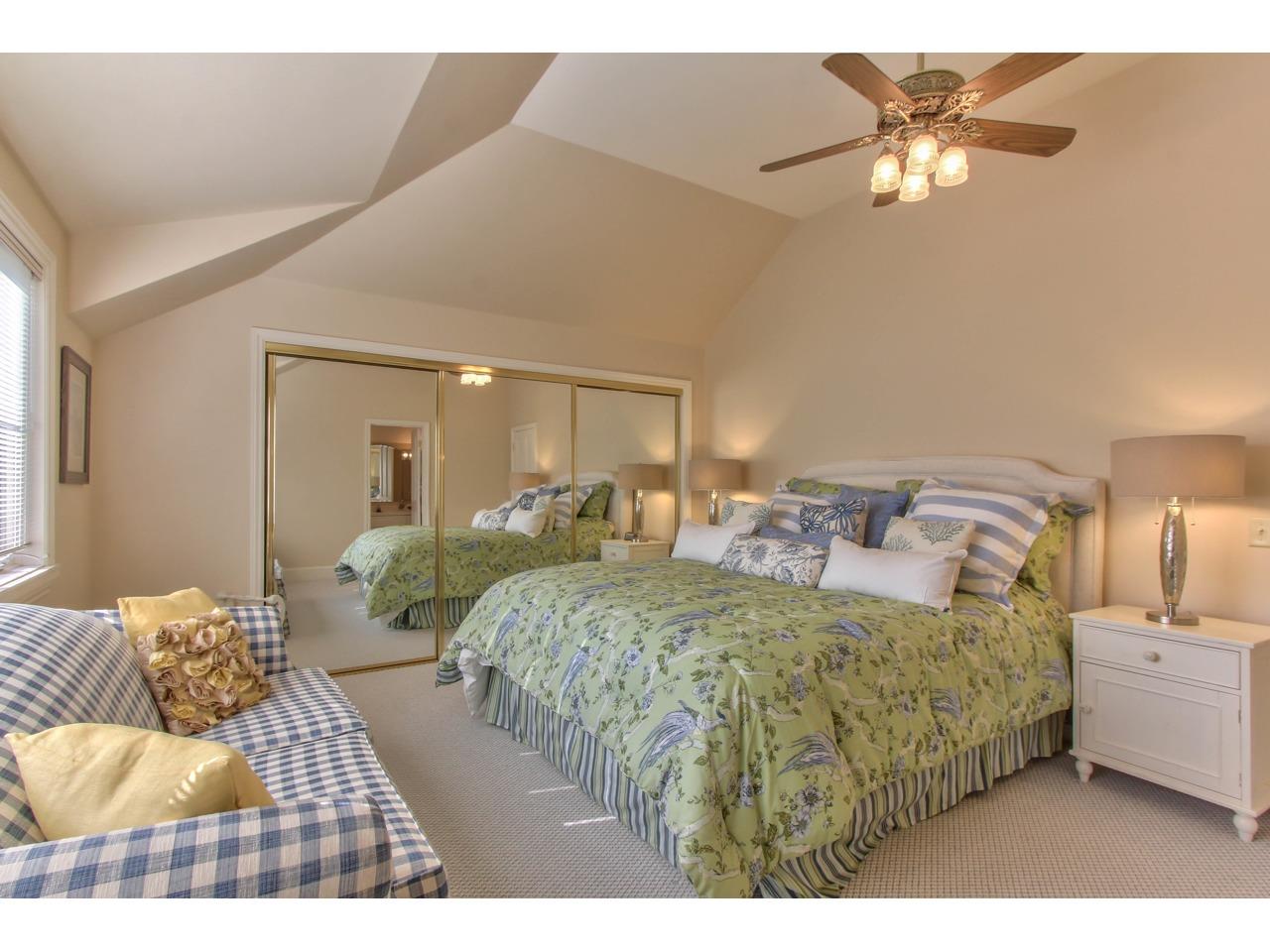 3140 Spruance Road Pebble Beach, CA 93953 - Photo 63 of 70 a bedroom with a large bed and a chandelier