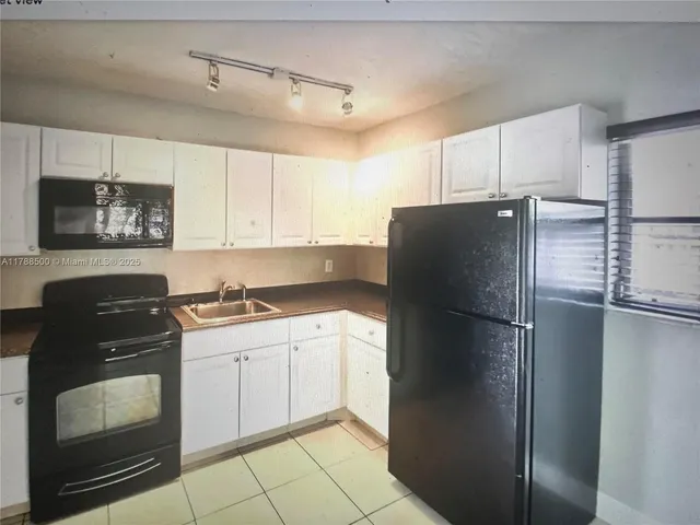 a kitchen with a refrigerator and a stove top oven
