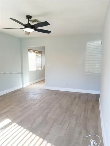 a view of a livingroom with wooden floor and a ceiling fan
