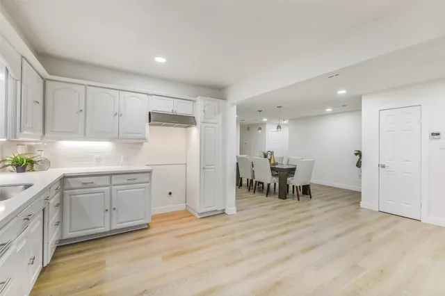 a kitchen with white cabinets and stainless steel appliances