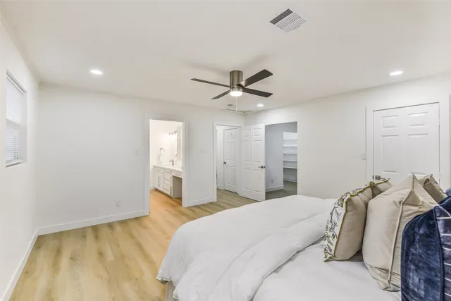 a bedroom with a large bed and a ceiling fan
