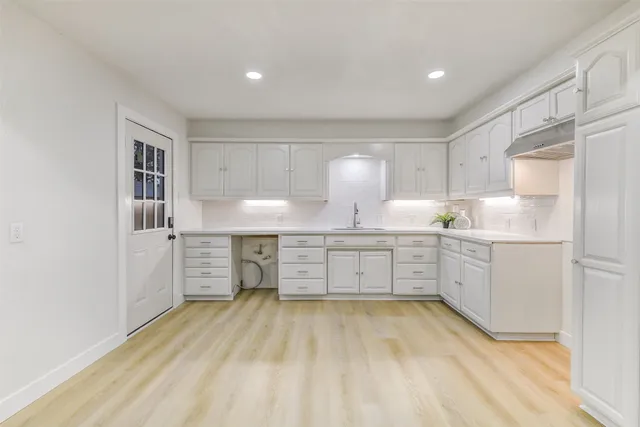 a kitchen with a refrigerator a sink and cabinets
