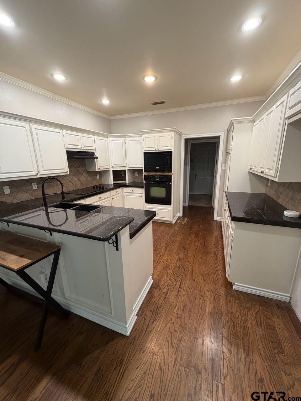 3204 Pebblebrook Circle Tyler, TX 75707 - Photo 2 of 18 a kitchen with stainless steel appliances granite countertop a stove a sink and a microwave