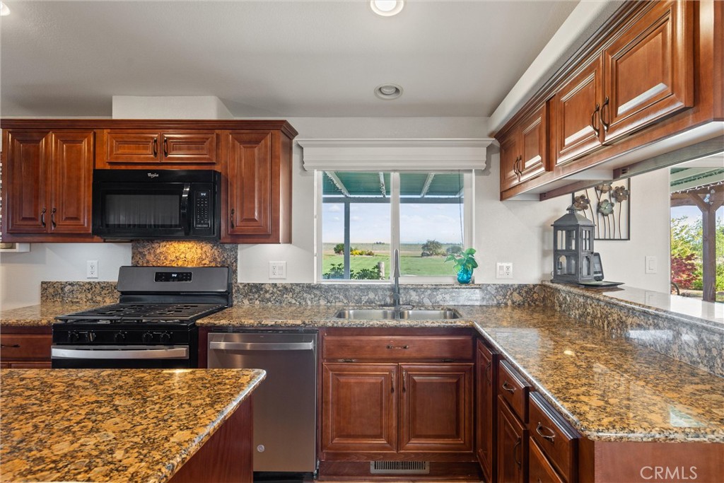 19350 Timbercove Drive Corning, CA 96021 - Photo 11 of 60 a kitchen with granite countertop a sink a stove and a wooden cabinets