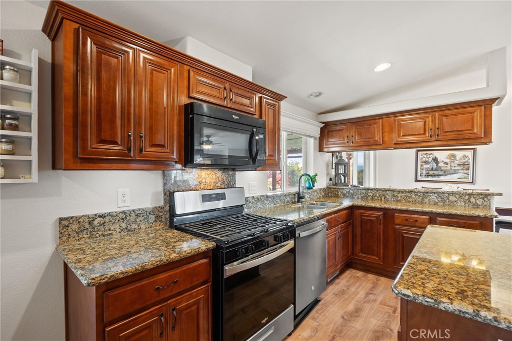 19350 Timbercove Drive Corning, CA 96021 - Photo 12 of 60 a kitchen with stainless steel appliances granite countertop wooden cabinets stove top oven and granite counter top