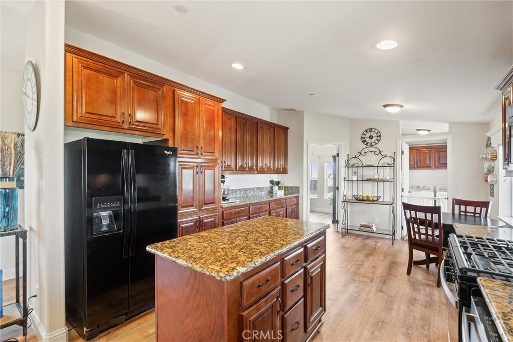 19350 Timbercove Drive Corning, CA 96021 - Photo 15 of 60 a kitchen with stainless steel appliances granite countertop a stove refrigerator and a dining table with wooden floor