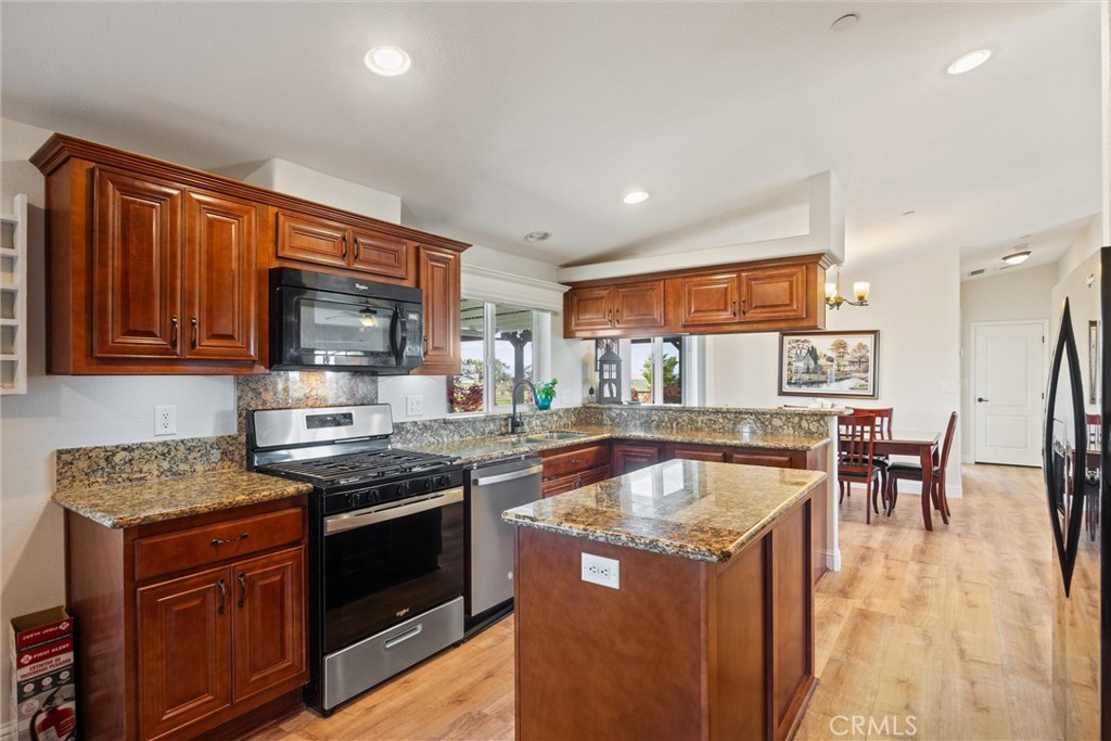 19350 Timbercove Drive Corning, CA 96021 - Photo 19 of 60 a kitchen with stainless steel appliances granite countertop wooden cabinets a stove a sink a dining table and chairs
