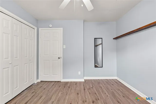 an empty room with wooden floor and mirror