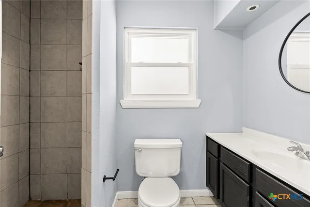 a bathroom with a toilet sink and mirror