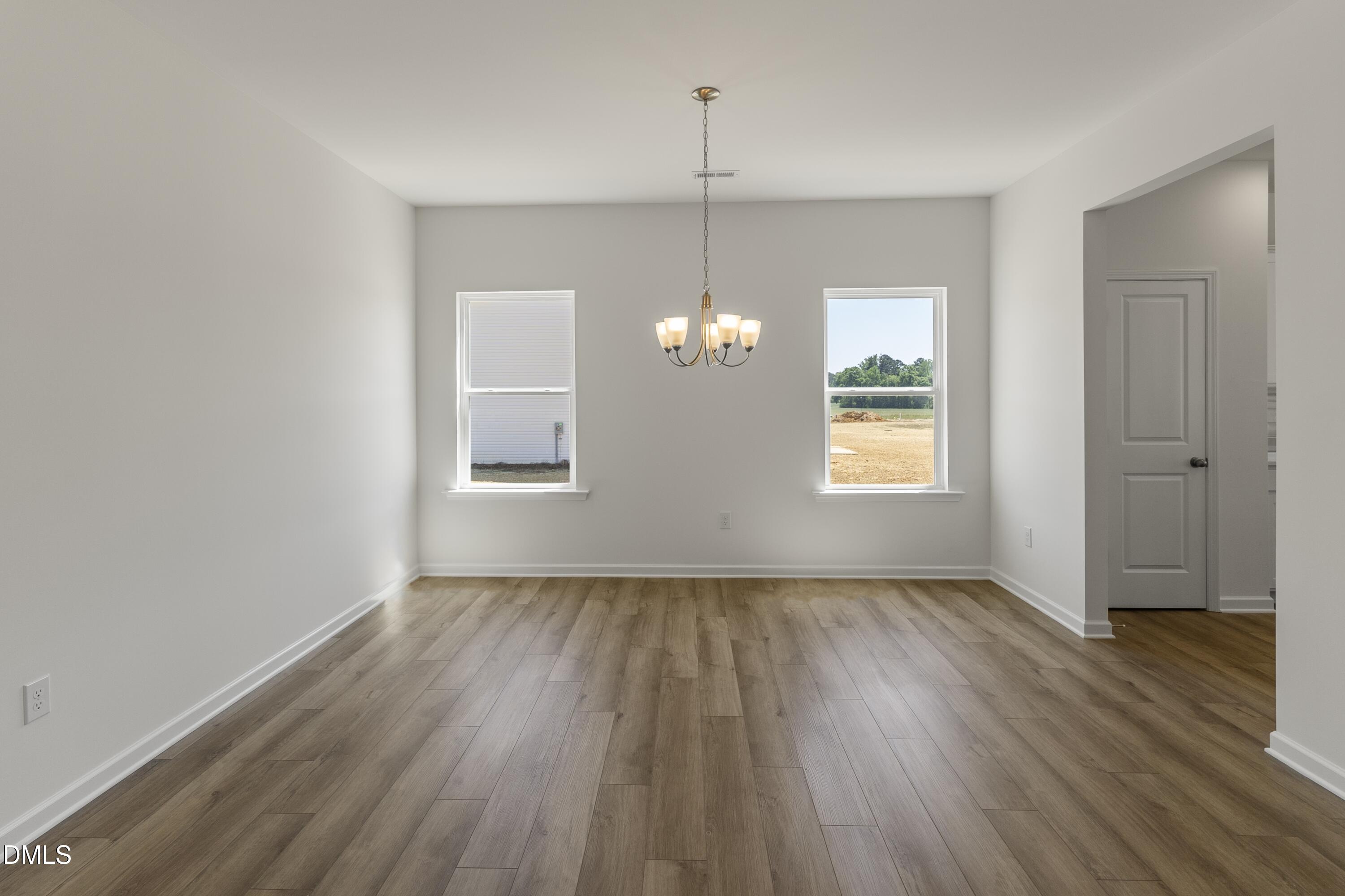243 Spirit Spgs Road Smithfield, NC 27577 - Photo 2 of 20 an empty room with wooden floor and windows
