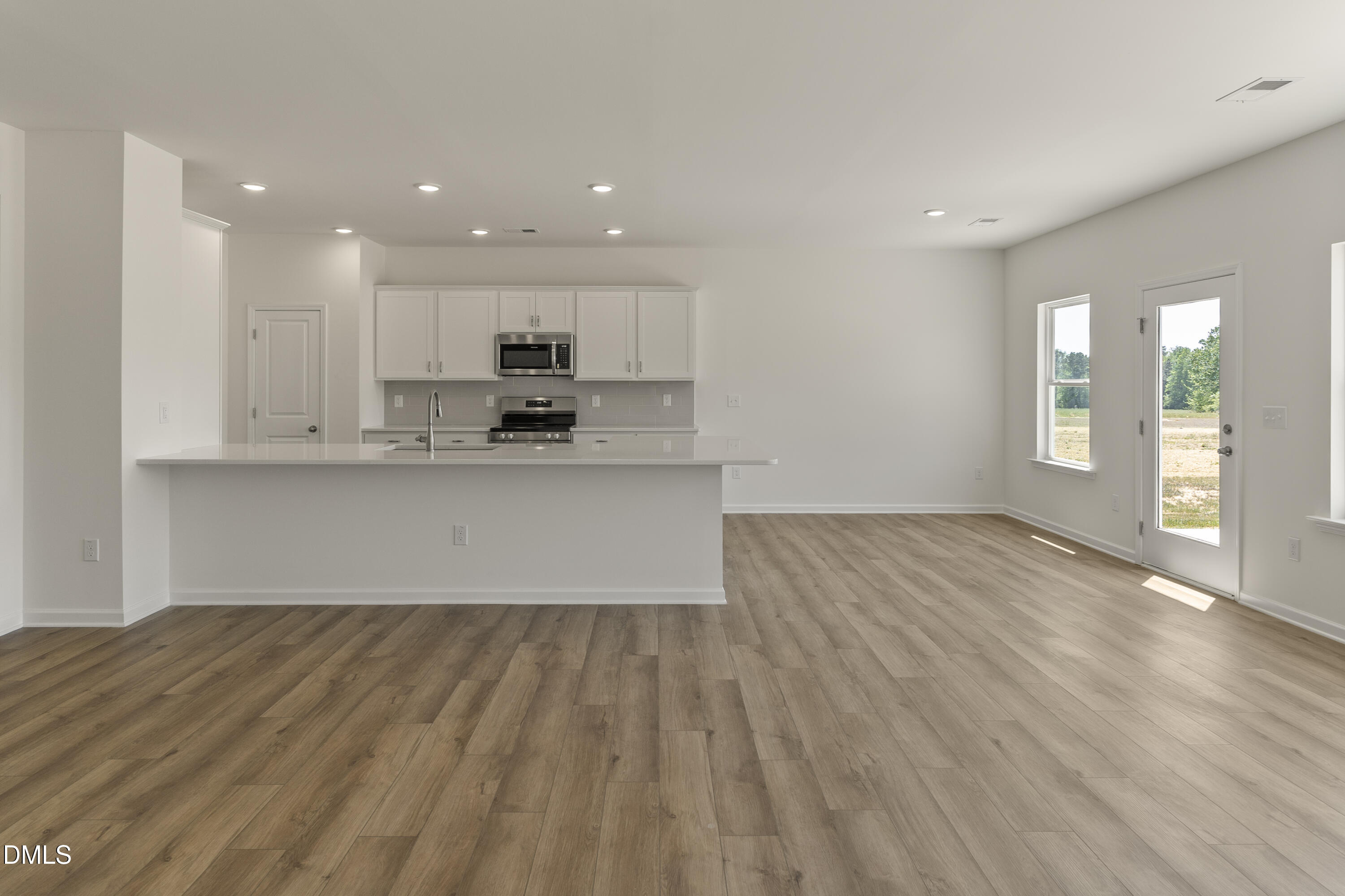 243 Spirit Spgs Road Smithfield, NC 27577 - Photo 6 of 20 a view of kitchen with wooden floor and window
