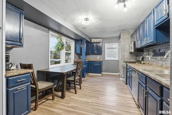 a kitchen with stainless steel appliances granite countertop a sink stove and wooden cabinets