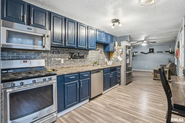 a kitchen with stainless steel appliances granite countertop wooden cabinets a stove top oven a sink and dishwasher