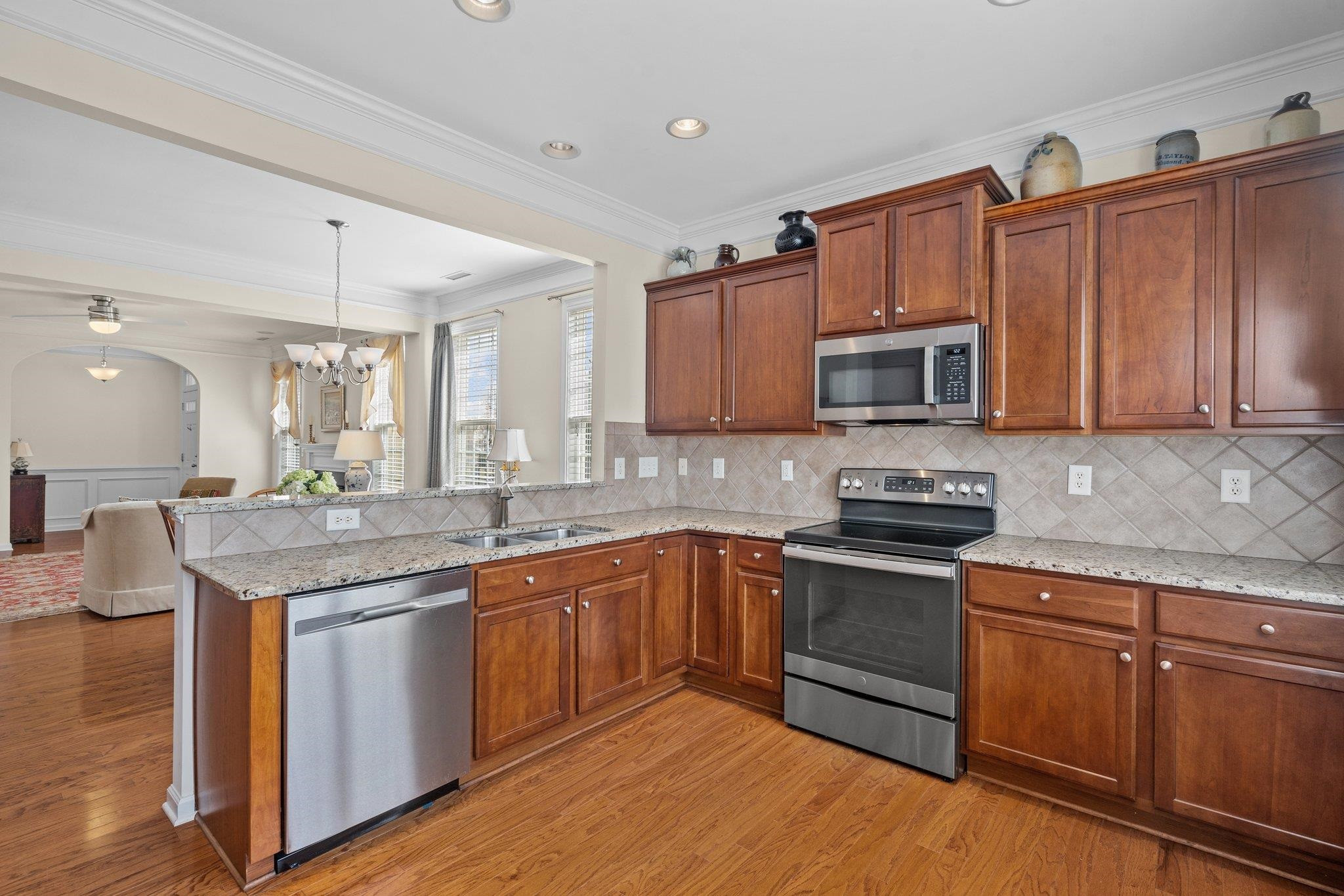 10109 Falls Meadow Court Raleigh, NC 27617 - Photo 12 of 37 a kitchen with stainless steel appliances granite countertop a sink stove and microwave