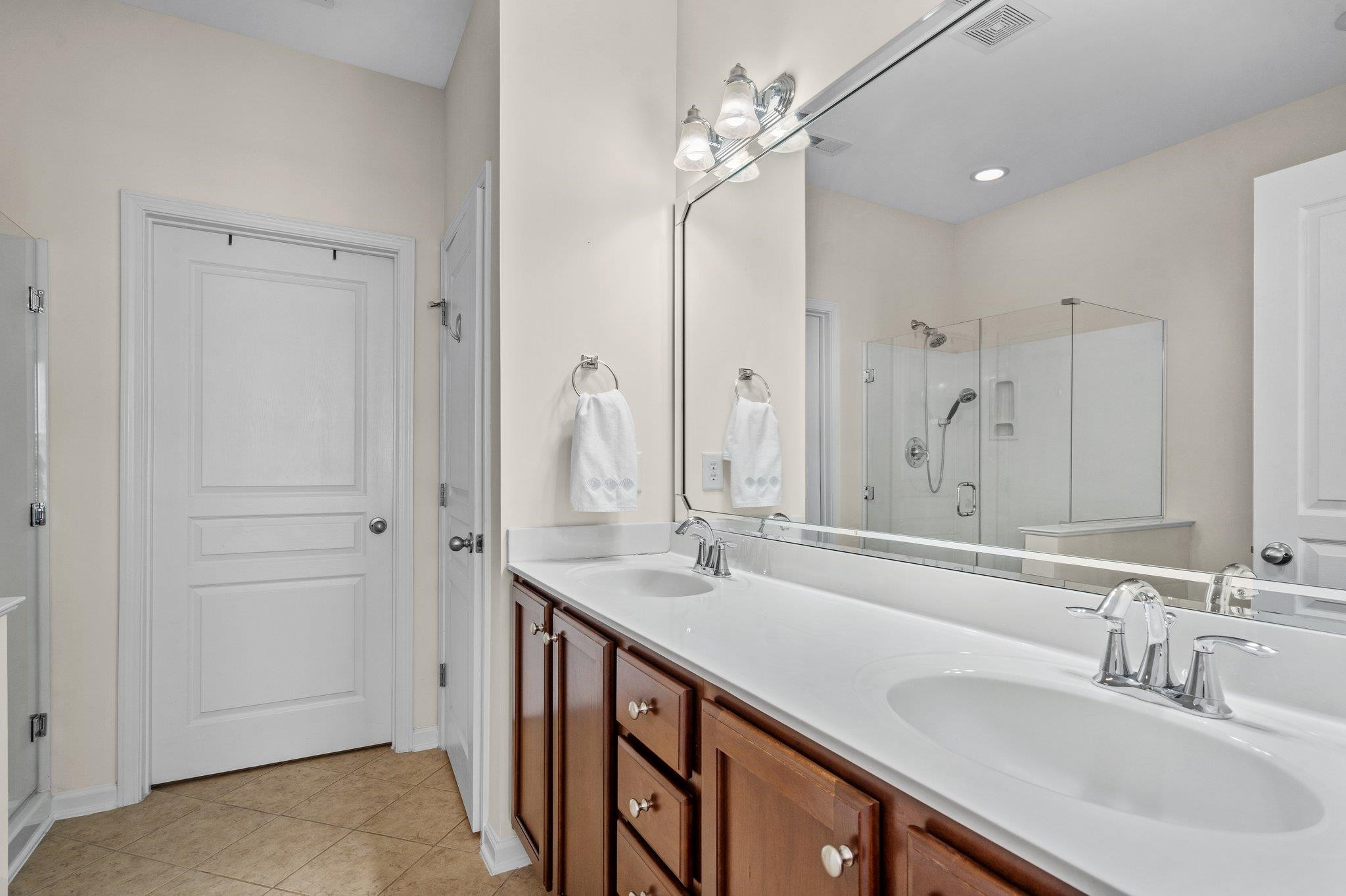 10109 Falls Meadow Court Raleigh, NC 27617 - Photo 17 of 37 a bathroom with a double vanity sink a mirror and a shower