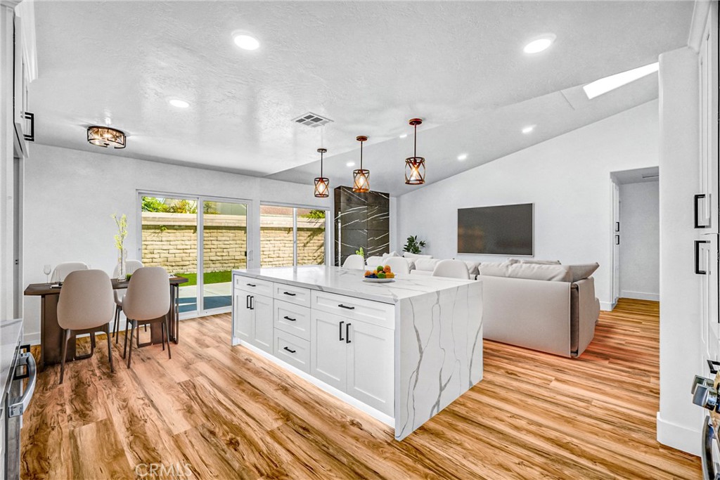 17472 Bellport Circle Huntington Beach, CA 92649 - Photo 3 of 23 a large white kitchen with a large window and stainless steel appliances