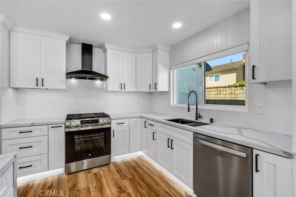 17472 Bellport Circle Huntington Beach, CA 92649 - Photo 8 of 23 a kitchen with a sink stove and cabinets