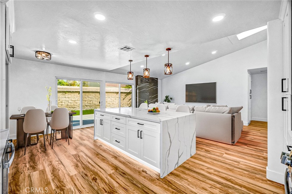 17472 Bellport Circle Huntington Beach, CA 92649 - Photo 9 of 23 a large white kitchen with a large window and stainless steel appliances