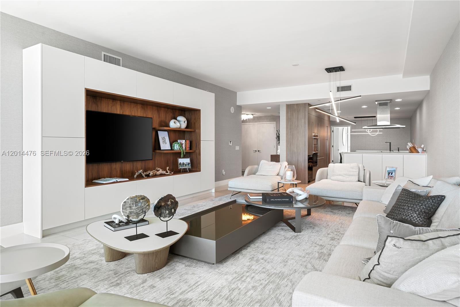 360 Ocean Drive, Unit 1106S Key Biscayne, FL 33149 - Photo 6 of 67 Living Room / Open Layout – The living room flows effortlessly toward the kitchen, with a custom media wall, built-in shelving, and contemporary lighting. The open-concept design enhances connection between the main gathering spaces.