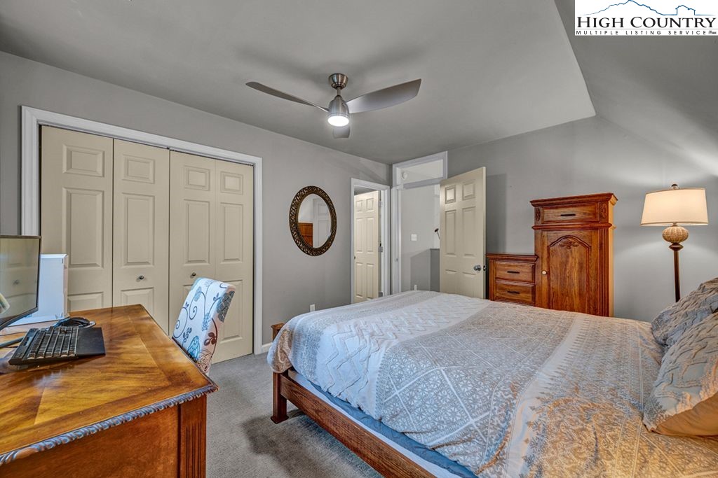 607 Charter Hills Road Beech Mountain, NC 28604 - Photo 13 of 31 a bedroom with a bed and a chandelier