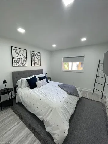 a bedroom with a bed and wooden floor