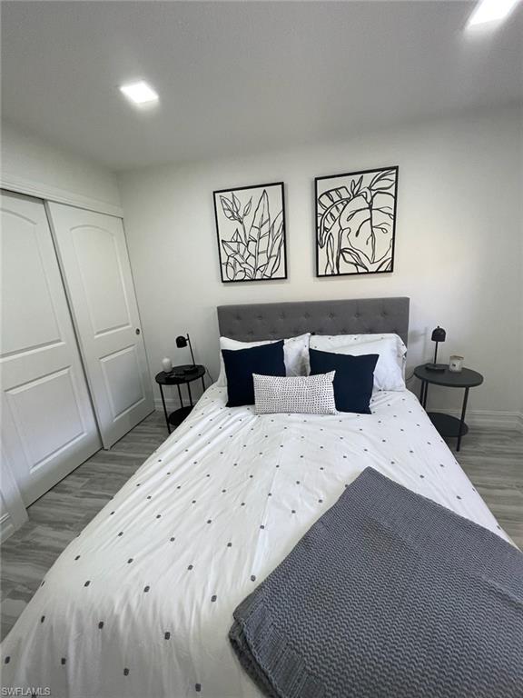 136 Harrison Road, Unit L3 Naples, FL 34112 - Photo 18 of 31 a bedroom with a bed and wooden floor