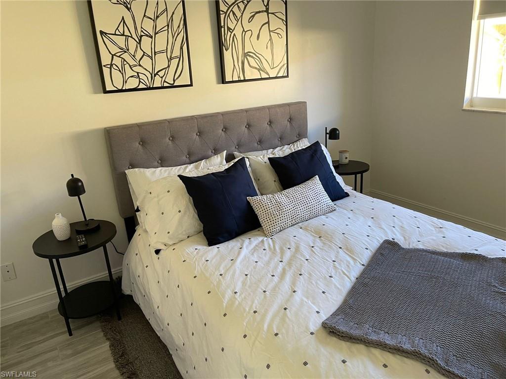 136 Harrison Road, Unit L3 Naples, FL 34112 - Photo 19 of 31 a bedroom with a bed and wooden floor