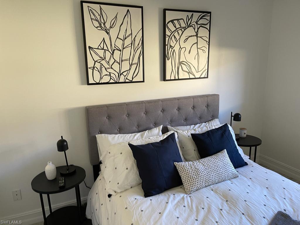 136 Harrison Road, Unit L3 Naples, FL 34112 - Photo 20 of 31 a bed sitting in a bedroom next to a wall with a painting on the wall