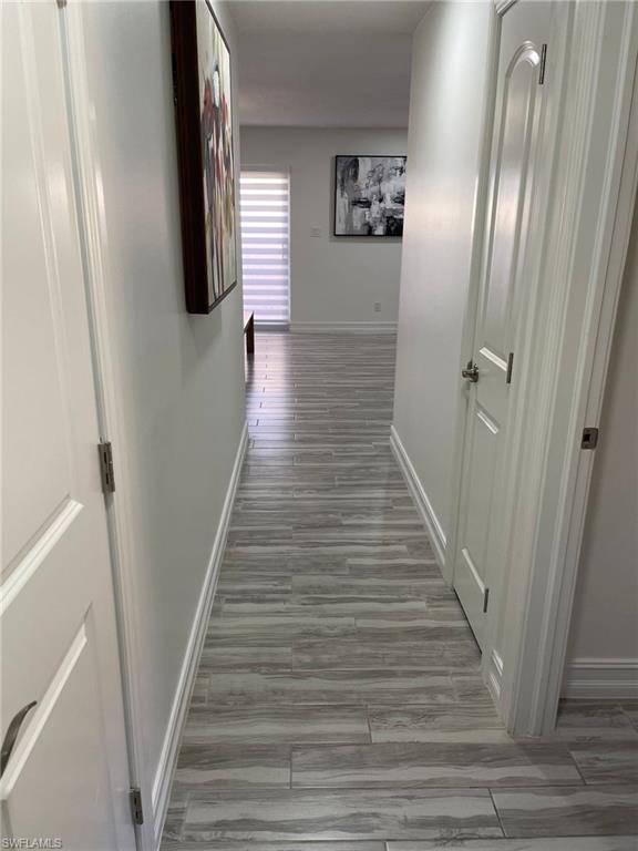 136 Harrison Road, Unit L3 Naples, FL 34112 - Photo 22 of 31 a view of a hallway with wooden floor and staircase