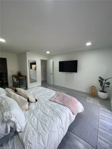 a bedroom with a bed and painting on the wall