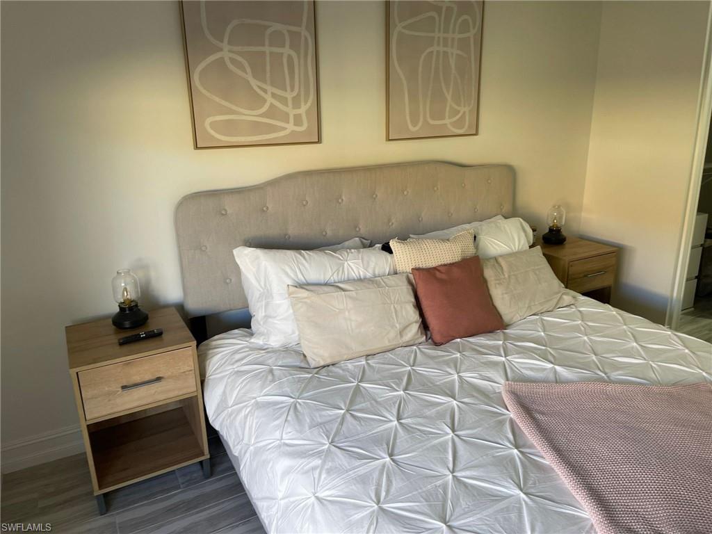 136 Harrison Road, Unit L3 Naples, FL 34112 - Photo 27 of 31 a bedroom with a bed and painting on the wall