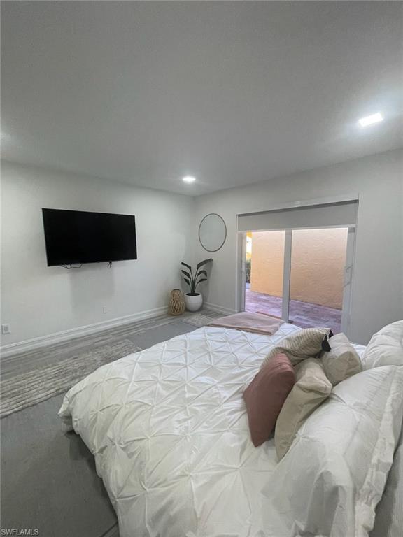 136 Harrison Road, Unit L3 Naples, FL 34112 - Photo 28 of 31 a bedroom with a bed and a flat screen tv