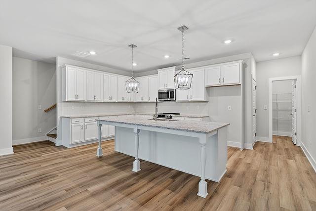 2562 Harbor Ridge Pass Gainesville, GA 30507 - Photo 7 of 27 a kitchen with a sink a window stainless steel appliances and cabinets