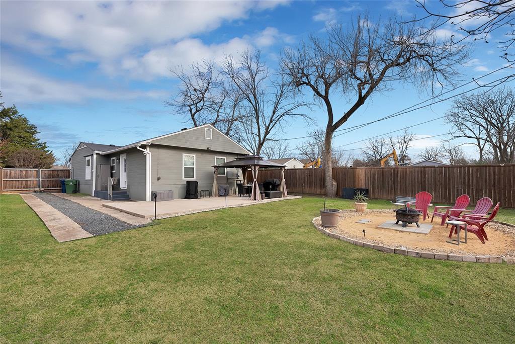 a view of a house with backyard and sitting area
