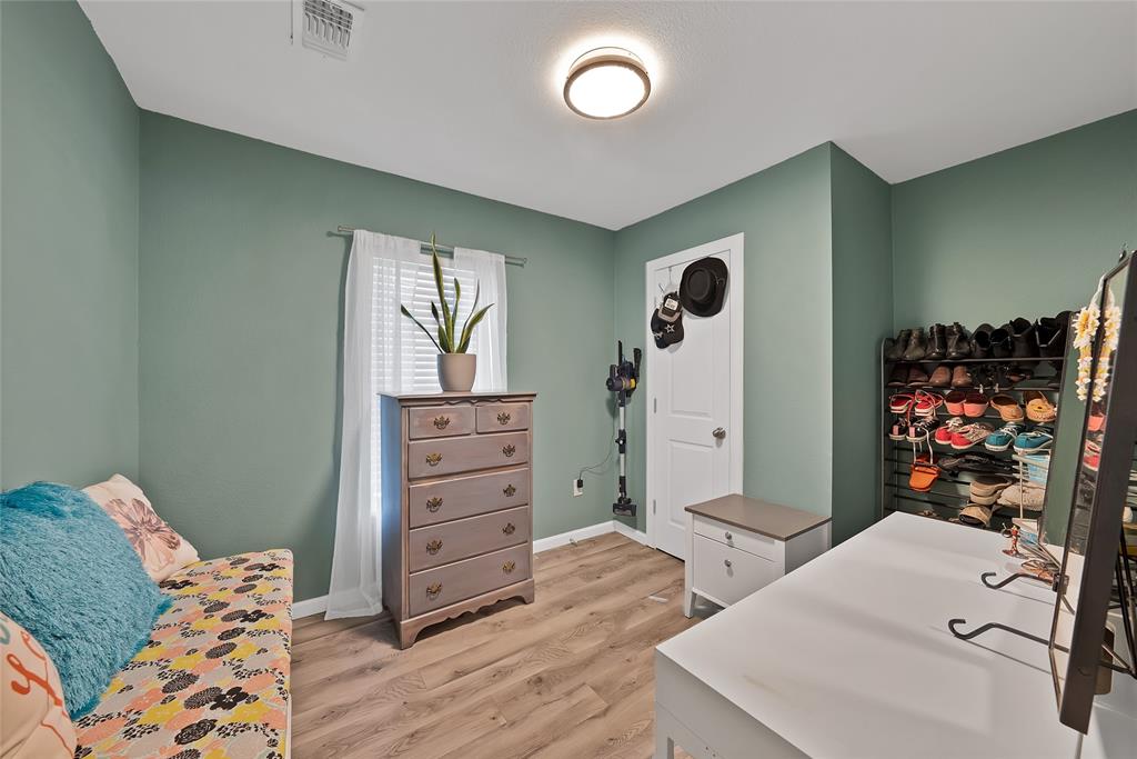 604 Moore Street Garland, TX 75040 - Photo 13 of 26 a bedroom with a bed and a dresser